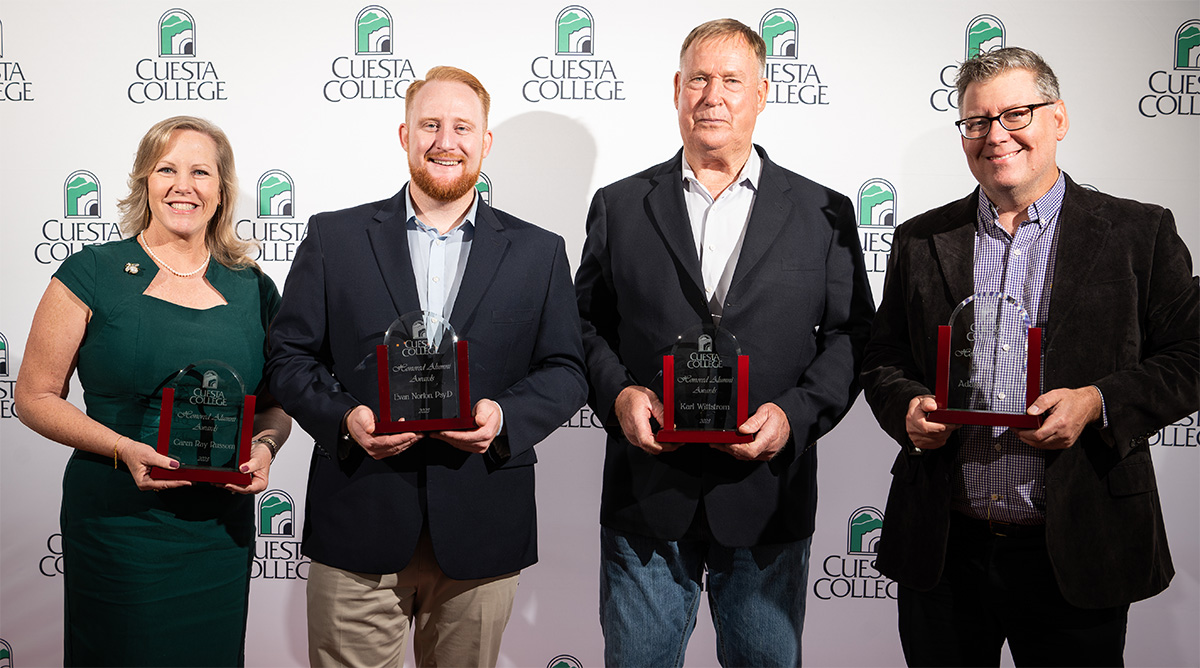 4 alumni with trophies